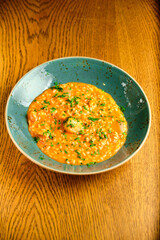 Tomato Risotto on a white restaurant plate.