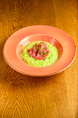 Green Risotto on a white restaurant plate.
