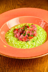 Green Risotto on a white restaurant plate.