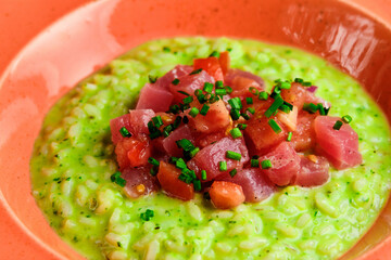 Green Risotto on a white restaurant plate.