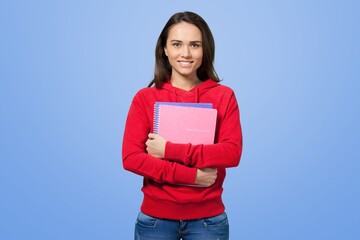 Obraz premium Smiling young student girl shows with books, confident in her knowledge, wearing shirt, white t-shirt