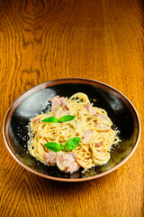 Italian recipe Pasta tortilloni with green pea, mint leaves, cheece, smoked bacon and cheese. Top view, blue background