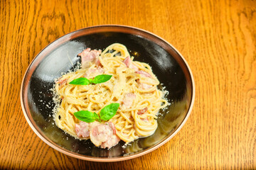 Italian recipe Pasta tortilloni with green pea, mint leaves, cheece, smoked bacon and cheese. Top view, blue background