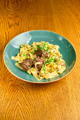 Italian recipe Pasta tortilloni with green pea, mint leaves, cheece, smoked bacon and cheese. Top view, blue background