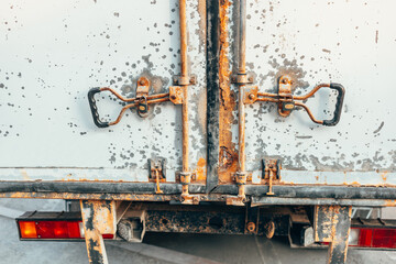 Rusty doors of an old truck. An old car. Rust on the body. Closed doors.