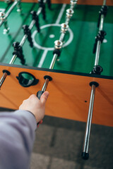 Table football, kicker. A woman's hand holds the control knob.