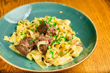 Italian recipe Pasta tortilloni with green pea, mint leaves, cheece, smoked bacon and cheese. Top view, blue background