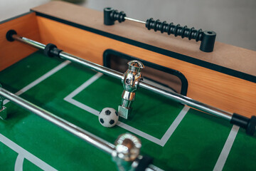 Table football. Kicker. A shiny figure from table football. Green field. The goalkeeper defends his goal.