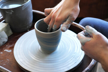 Fototapeta na wymiar pottery, workshop, pottery art concept - close-up on male hands sculpt new utensils