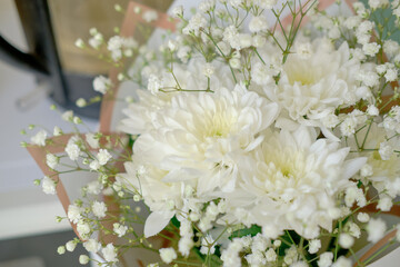 bouquet of white chrysanthemums and gypsophila wrapped in craft paper. delicate bouquet of white flowers. Spring bouquet of white chrysanthemums close-up.
