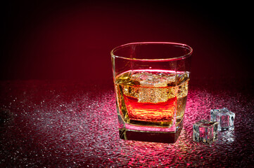 Glass transparent glass with a drink and ice cubes for cooling.