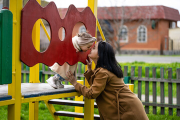 Child education concept. Mom and daughter are playing on the playground.