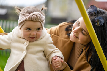 Child education concept. Mom and daughter are playing on the playground.