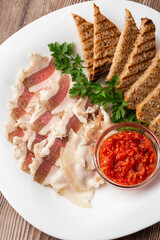Raw chopped pork lard with meat, a head of garlic and rye bread on a wooden background for copy space. A large chunk of fresh fat.