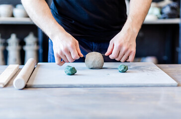 potter, clay workshop, ceramics art concept - male cuts raw clay