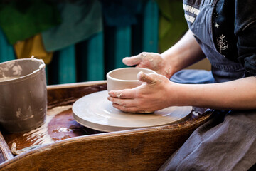 Cropped image of unrecognizable pottery woman working with pottery wheel