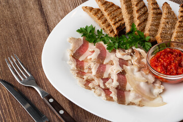 Raw chopped pork lard with meat, a head of garlic and rye bread on a wooden background for copy space. A large chunk of fresh fat.
