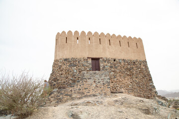 fort in dry Arabian desert on hill top ancient ruins with grain and out of focus