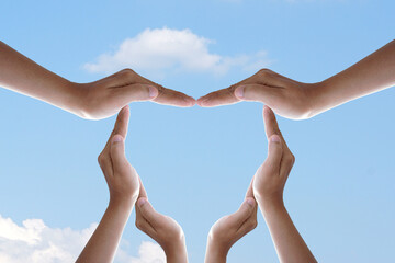 human hand made heart blue sky background
