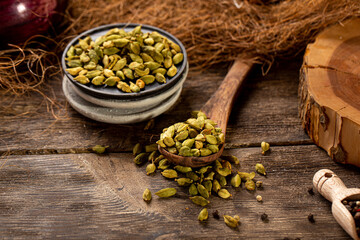 Cardamom spice seeds on the wooden background