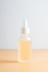 Side view of frosted glass dropper bottle with beauty face oil on beige background. anti aging serum with natural engredients.