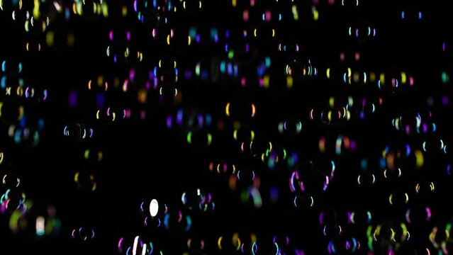 Slow motion of soap water bubbles texture flying over black abstract background
