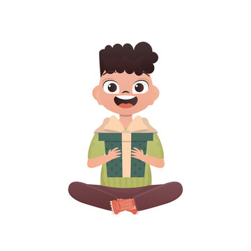 A small boy child is depicted in the lotus position and holding a box with a bow in his hands. Birthday, New Year or holidays theme. Cartoon style, isolated.