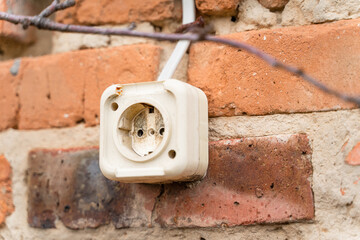 Old plastic street socket on an old brick wall close-up