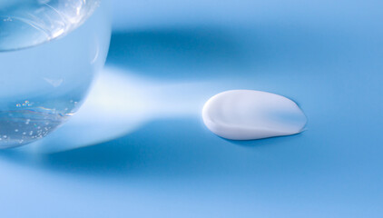 cosmetic smear of cream on a blue background with a beam of light	
