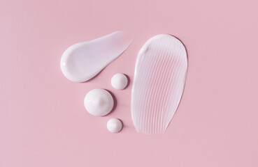 cosmetic smears cream texture on pastel pink background	
