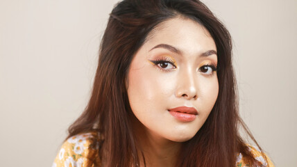 Smiling young Asian woman wearing makeup isolated with white background. Beauty concept.