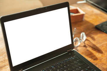 Computer screen mockup. Laptop with white blank screen on a wood desk, office background, copy space
