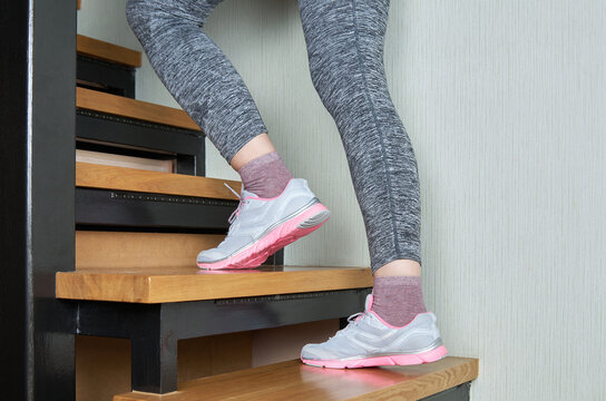 Sports woman legs in sport shoes on stairs