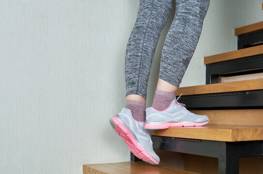 Sports woman legs in sport shoes on stairs