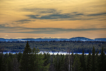 Beautiful cloudscape and orange sky over winter mountains