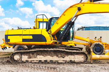 Powerful excavator work on a construction site, sunny blue sky in the background. Construction equipment for earthworks.