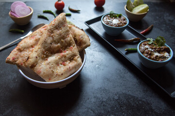 Indian meal menu Kabuli naan or flat bread along with black lentil soup. Close up, selective focus.