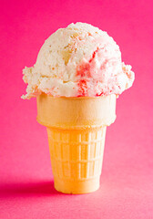 Strawberry Cheesecake Ice Cream in a Cone on a Pink Surface