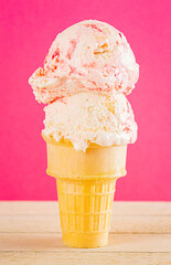 Strawberry Cheesecake Ice Cream in a Cone on a Pink Surface