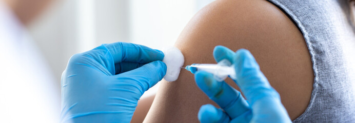 Vaccination of patients, Doctor provided a vaccine with a syringe against a new strain of  virus or...