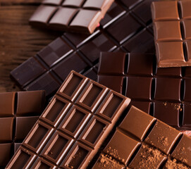 Dark homemade chocolate bars and cocoa pod on wooden