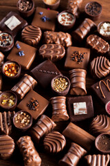 Chocolate bars and pralines on wooden background