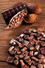 Chocolate bars and pralines on wooden background