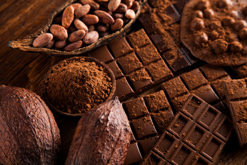 Dark homemade chocolate bars and cocoa pod on wooden