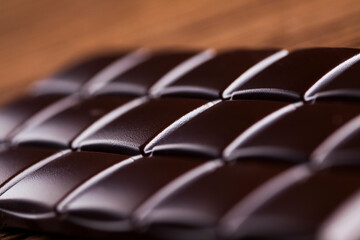 Dark homemade chocolate bars and cocoa pod on wooden