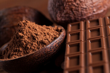 Chocolate bar, candy sweet, cacao beans and powder on wooden background