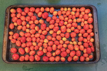 Authentic roasted winter grape tomatoes in a roasting pan cookie sheet healthy ingredients for fresh Italian pasta sauce for a Mediterranean diet.