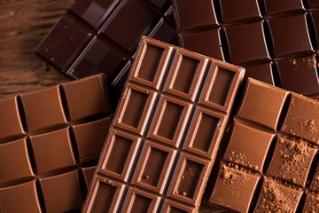 Dark homemade chocolate bars and cocoa pod on wooden
