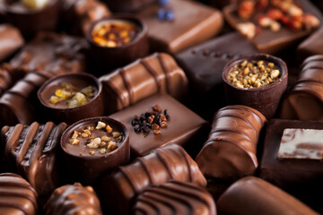 Chocolate bars and pralines on wooden background