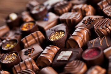 Chocolate bars and pralines on wooden background